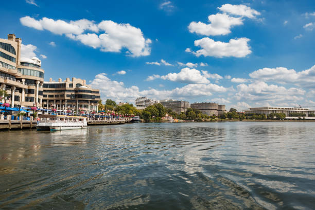 Shops and Restaurants on the Georgetown Waterfront in Washington, DC Washington, DC USA - August 30, 2016: Wide angle view of the Georgetown Waterfront showing the shops and restaurants, Thompson Boat Center, Watergate Hotel and the Kennedy Center hotel watergate stock pictures, royalty-free photos & images
