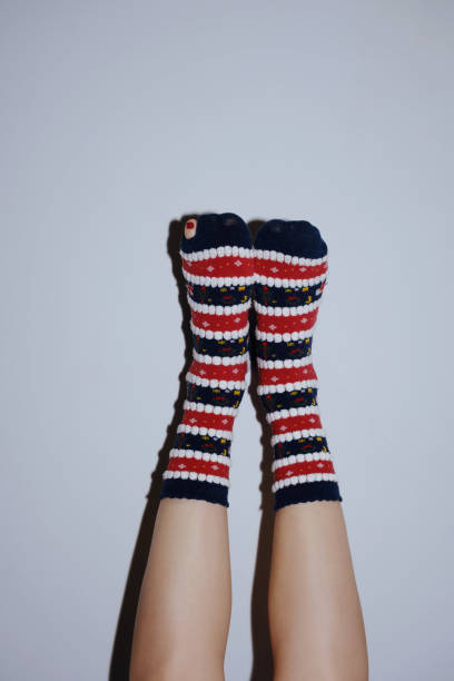 istock legs in christmas socks raised up on grey 1447789391