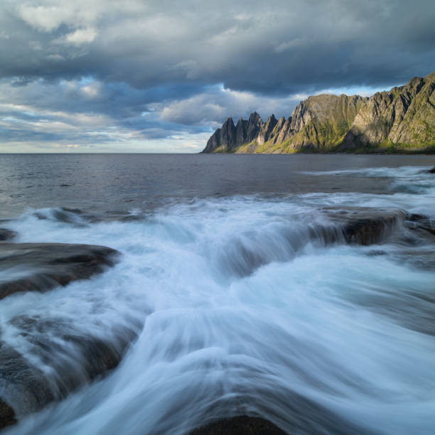 Waves flow over rocky shoreline at Tungeneset viewpoint, Senja, Norway in Ersfjord, Troms og Finnmark, Norway