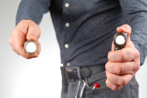 istock man holds a flashlight in his hand. item for camping and household life 1447797344