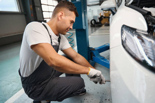 istock Handsome man changing car wheel in tire fitting 1447798593
