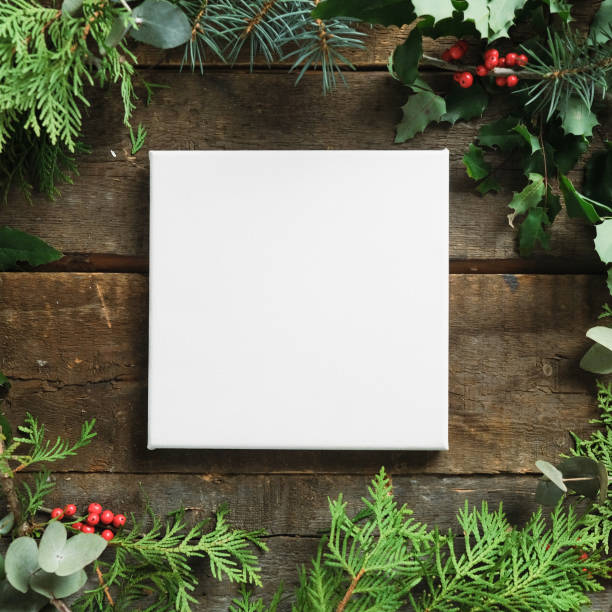 istock Christmas frame. Blank canvas on wooden background with Christmas greenery. 1447800934