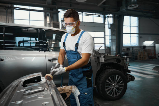 istock Technician peel off old paint from car part 1447801845