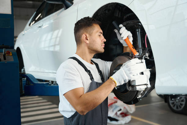 istock Male removing old wheel from car in tire fitting 1447802644