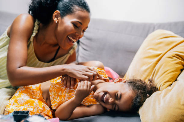 istock A Happy Beautiful Cute Girl Laughing While Playing With Her Nanny On The Sofa 1447806529