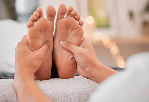 Spa, feet and massage for relax, wellness and health on bed with hands, luxury and physical therapy. Professional, foot rub and service for healthcare, foot massage and healthy body care treatment