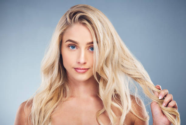 Woman, blonde, hair care on gray studio background in hair dye advertising, treatment or texture hair style. Portrait, beauty model or face with makeup cosmetics, healthy skincare or long hair growth mujer, rubia, cuidado del cabello sobre fondo de estudio gris en publicidad de tinte para el cabello, tratamiento o textura de peinado. retrato, modelo de belleza o cara con cosméticos de maquillaje, cuidado de la piel saludable o crecimiento del cabello