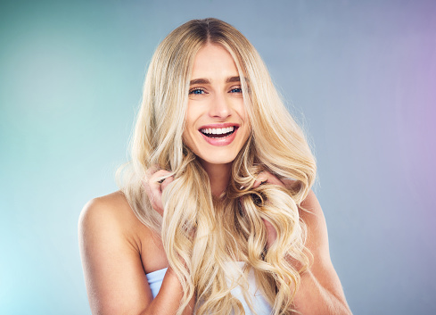 Studio portrait of blonde teen girl on gray background