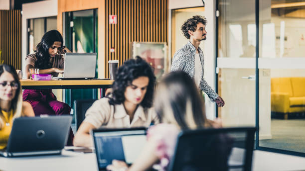 istock One coworker passing by the office tables 1447812887