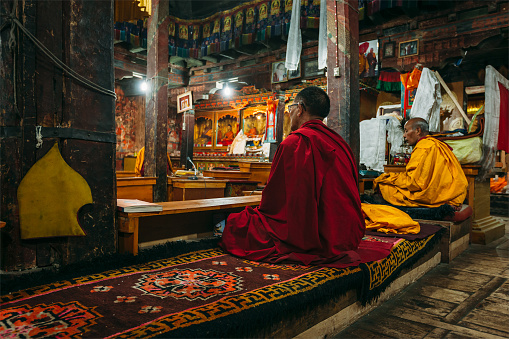 Thiksey, India - September 4, 2011: Tibetan Buddhist monks during prayer in Thiksey gompa (Buddhist monastery) of the Yellow Hat (Gelugpa) sect - the largest gompa in central Ladakh