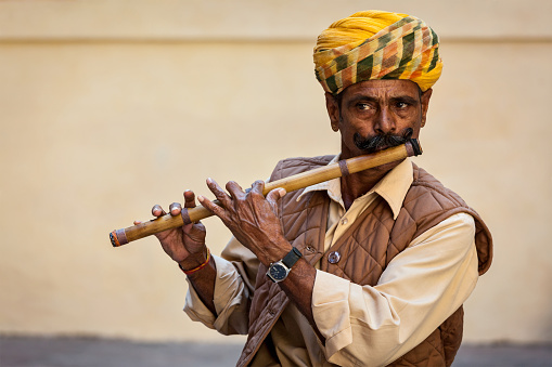 Jodhpur, India - November 26, 2012: Indian man plays wooden flute in Mehrangarh fort, Rajasthan, India