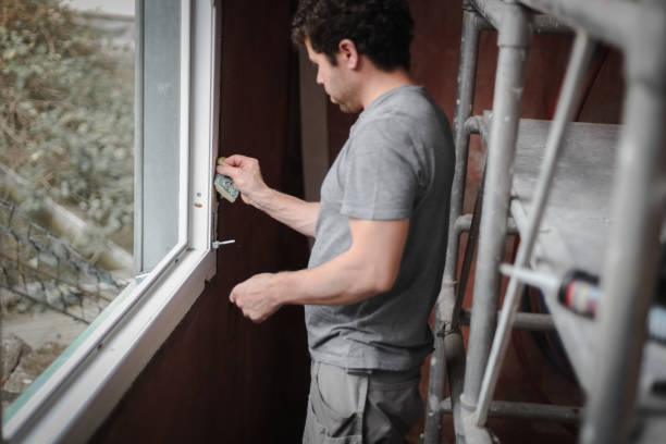 istock Caucasian man with a sponge washes the window frame. 1447813986