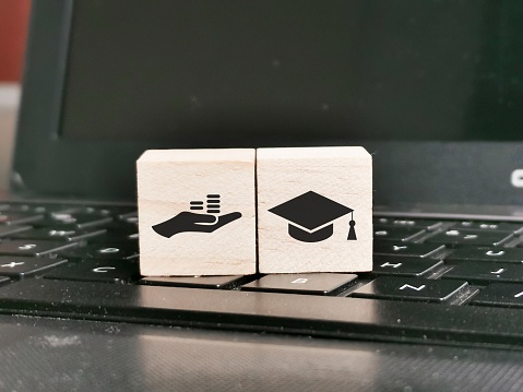Free Application for Federal Student Aid concept with wooden cubes on laptop.