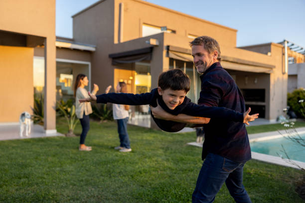 istock Father playing with his son outdoors and carrying him like an airplane 1447820932