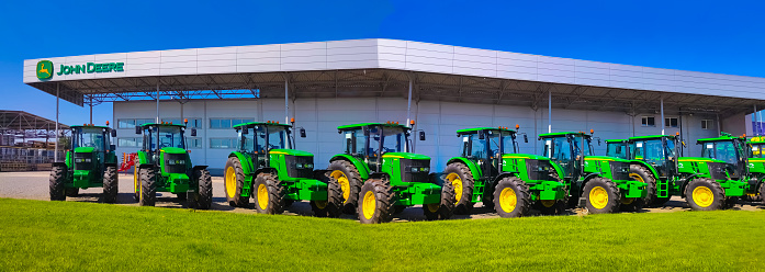 Kyiv, Ukraine - August 24, 2020: The Powerful tractors at John Deer store at Kyiv, Ukraine on June 16, 2020. Row of brand new John Deere tractors outside the store of local consortium, exhibition of latest agricultural machinery.
