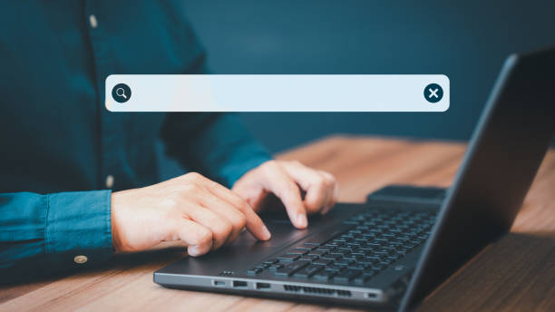 istock Businessman's hand working with computer laptop on desk in home. Searching Browsing Internet Data Information with blank search bar. Search Engine Optimization SEO Networking Concept. 1447825967