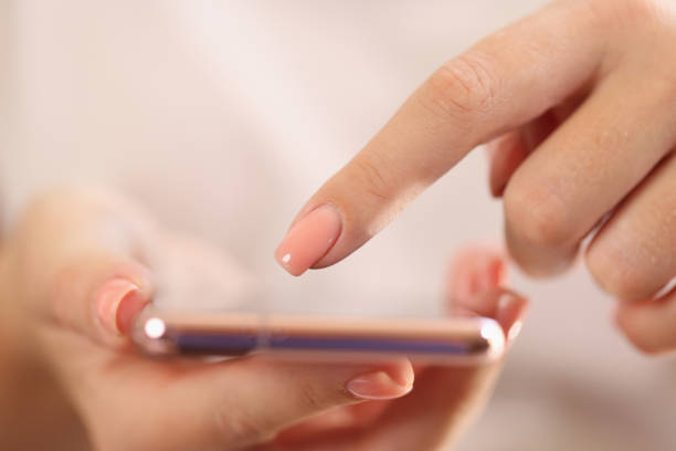 istock Female hands holding modern smartphone in hands and pointing on screen with finger 1447826081