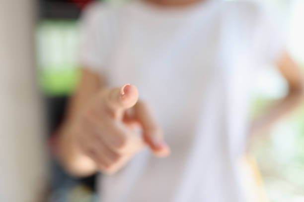 Close-up of female hand pointing at camera with finger. Choosing, inviting people or recruiting concept