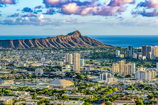 A large panoramic view of Waikiki buildings and Diamond Head at dusk.