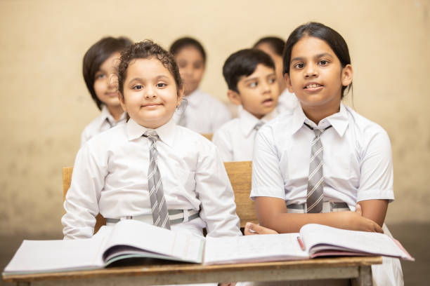 istock Indian elementary school students sitting at desk in classroom with textbook, Girl Education concept. 1447832583