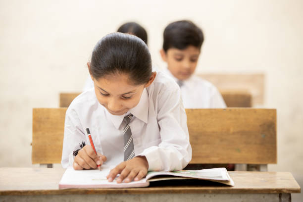 istock Indian girl student studying in classroom, Writing note, school and education concept 1447832646