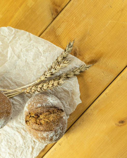 istock Homemade whole-grain sourdough bread, wheat grains and spikelets. Wheat bread spikelets. Spikelets of fresh wheat bread on a brown wooden background. 1447834618