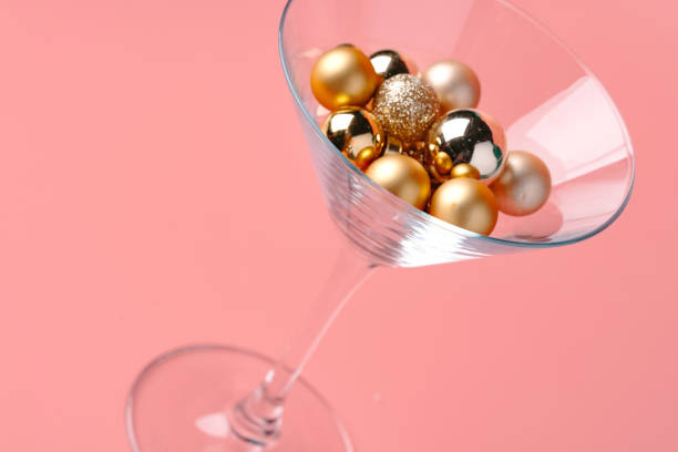 istock Glass with Christmas decorations on pink pastel background 1447837983