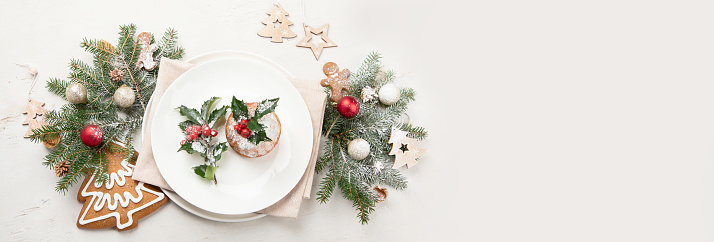 Christmas table setting with empty plate on light background. Winter Holidays conept. Top view. Copy space. Panorama, banner
