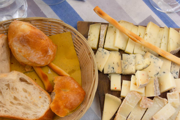Cheese variety tapas and bread basket. Traditional Spanish food on cutting board from top, snack, appetizer concepts
