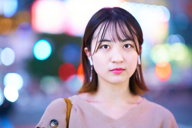 istock Young woman standing in downtown at night 1447843385