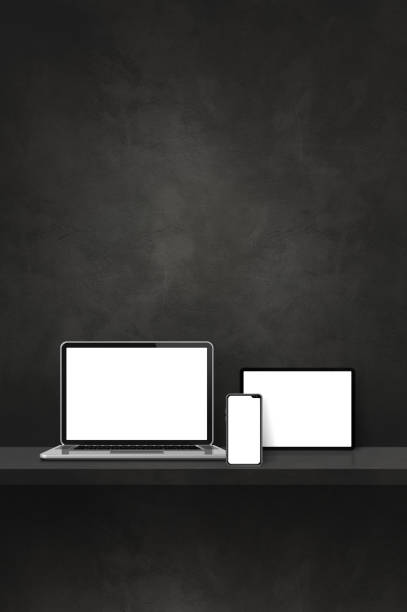 istock Laptop, mobile phone and digital tablet pc on black wall shelf. Vertical background 1447843681