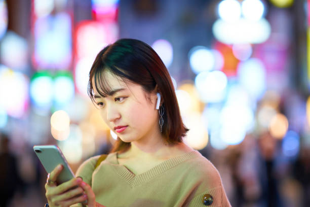 istock Young woman looking at smartphone at night 1447843929