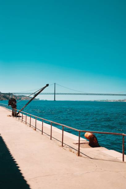 istock Ponte 25 de Abril suspension bridge view from a stone platform sunlit clear sky background 1447846805
