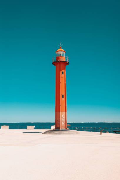 istock Vertical low-angle of Cacilhas Lighthouse seascape view clear sunlit sky background 1447846808