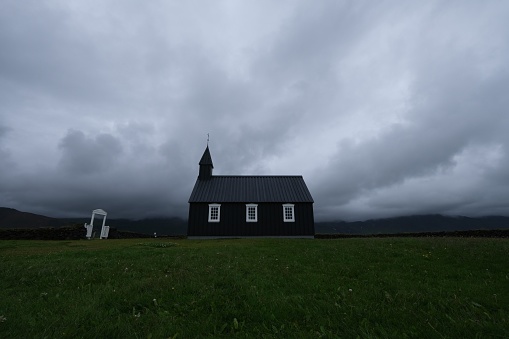 Black church in front of moody sky, iceland