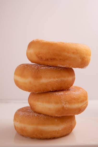 istock Vertical closeup of a stack of donuts served on a white background 1447849912