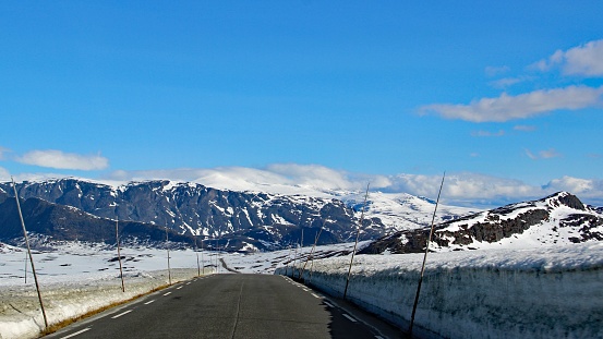Landscape of mountain massifs and empty asphalt road in winter scenery