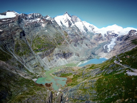 An aerial view of shallow lake between Alpine mountains and snowy Grossglockner in Austria