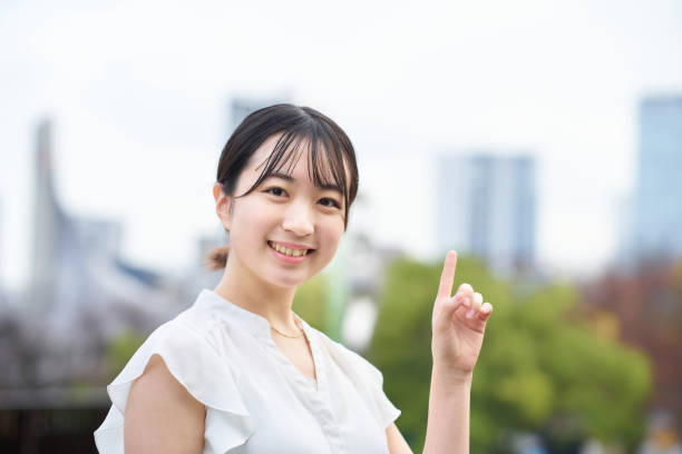 ポインティングポーズをとる若い女性 - business pointing women index finger ストックフォトと画像