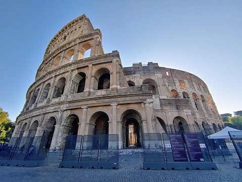 A low angle shot of a Coliseum building with blue sky in the background, Rome, Italy