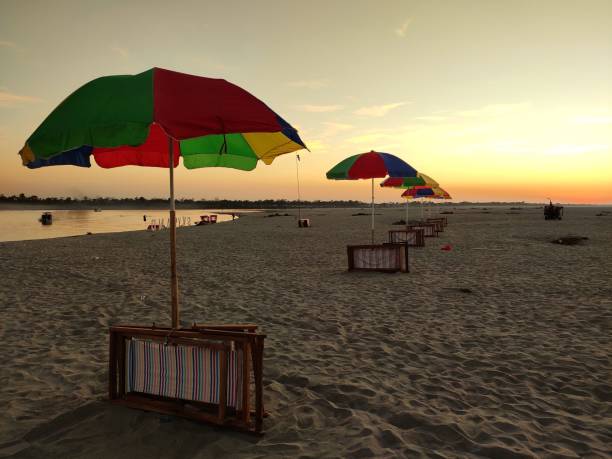 istock Colorful beach umbrellas at the shore at sunset 1447853604