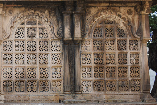 Maqbara's side close up view near the tomb of Sultan Ahmed, architecture exterior wall with intricate carvings in stone, Ahmedabad, Gujarat, India