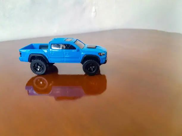 Diecast car in the wooden background. Toy photography concept. Background is blurred. Adventure car toys.