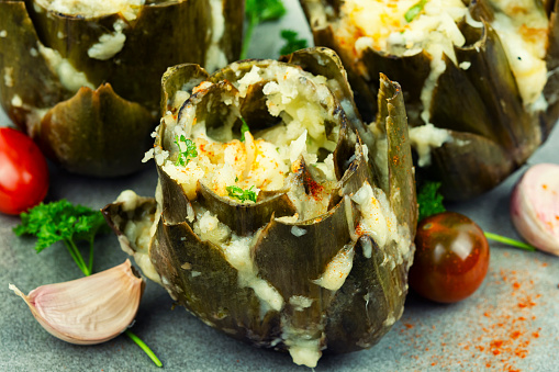 Delicious appetizer baked artichoke with cheese.Stuffed artichokes on a plate