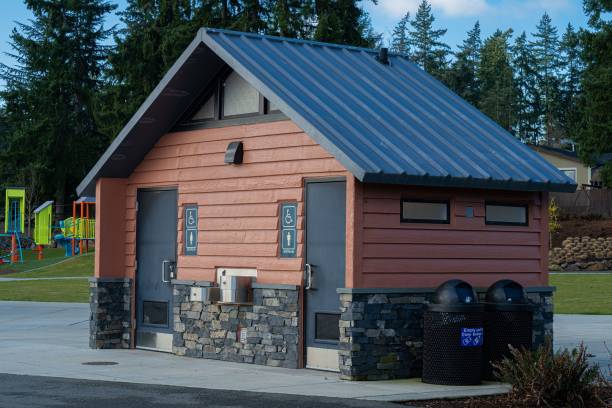 istock Public bathroom with triangular wooden architecture near a playfield 1447855787