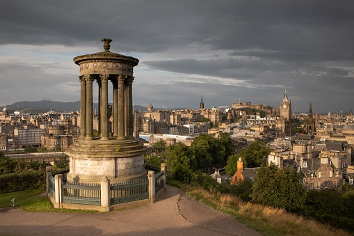 Dugald Stewart monument, on top of Calton Hill, in the Scottish capital city of Edinburgh, with views over Old and New Town. The famous skyline has new landmarks, including the St. James Quarter with its new shopping centre & apartment blocks. The new W hotel building has been nicknamed the walnut whip, because of its curved & wavy design.