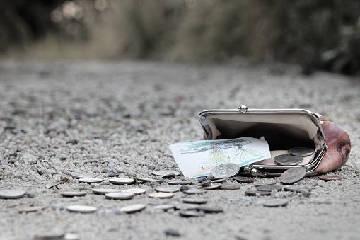 A closeup shot of a lost wallet with money on the ground on street