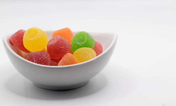 istock Colorful candies in a bowl isolated on white background 1447859025