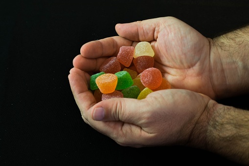 The male hands holding colorful candies