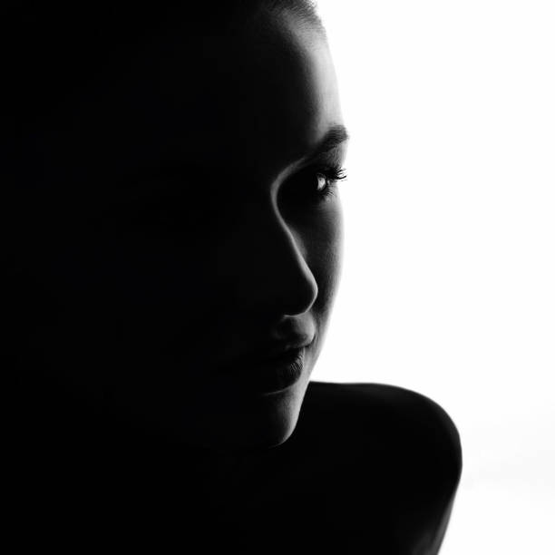 istock Part beautiful woman face silhouette covered in shadow 1447859725